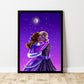 An original art print showing two young woman sharing a kiss in the snow against a purple night sky. A crescent moon is overhead.  The print is framed in black, sits on wooden floorboards and leans against a white wall.