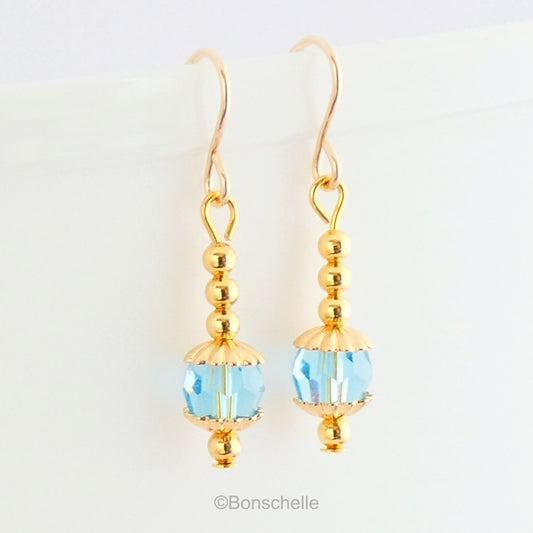 Handmade dangle earrings made with turquoise coloured Swarovski cut glass crystal faceted beads, small gold toned beads and 14K gold filled earwires.