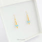 Handmade dangle earrings made with turquoise coloured Swarovski cut glass crystal faceted beads, small gold toned beads and 14K gold filled earwires shown in a jewellery box