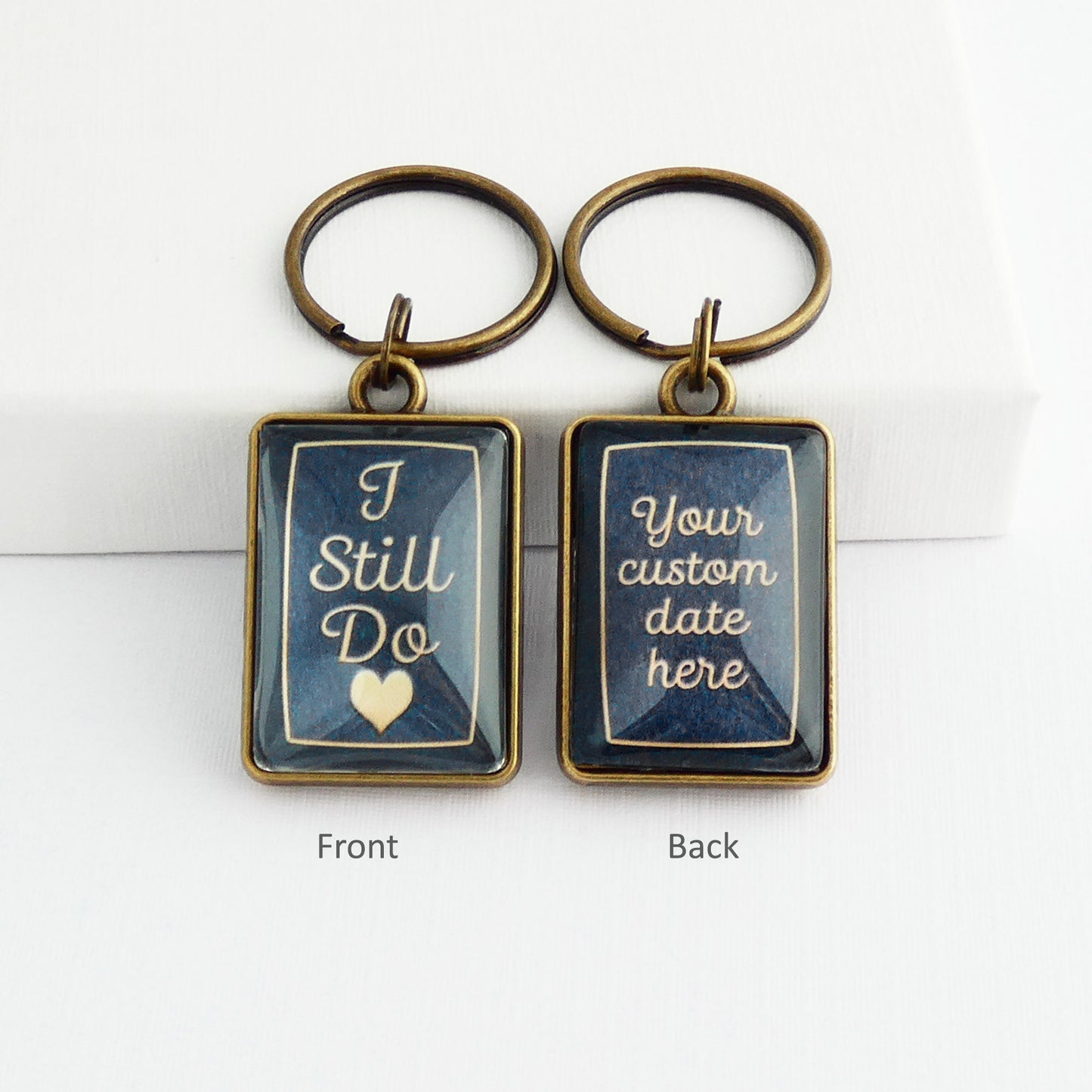 A double sided bronze and navy blue rectangle keyrings with the words I still do on the front and a personalised custom date on the back