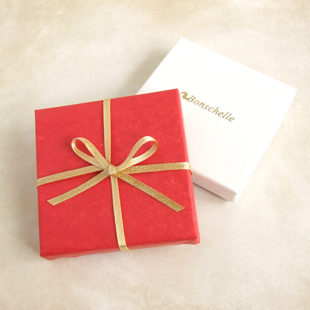 Image of a box wrapped with Bonschelle red tissue and gold bow 