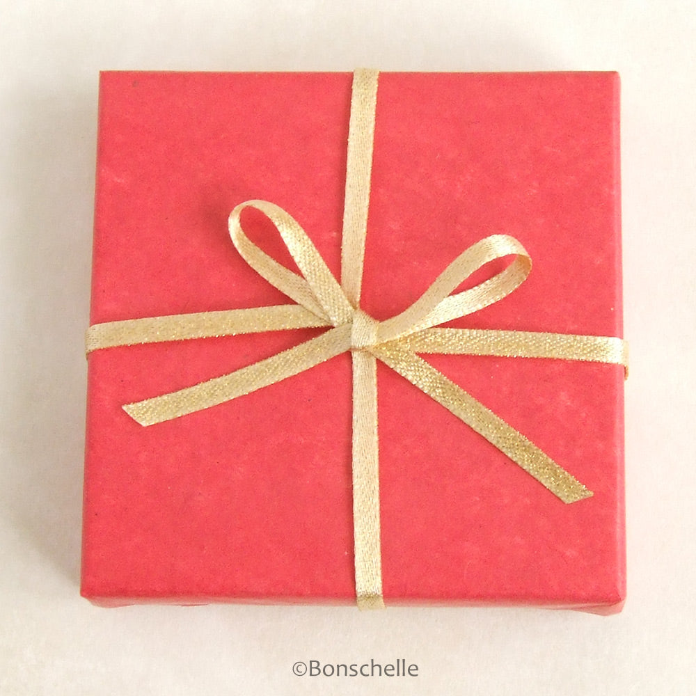 Image of a box wrapped with Bonschelle red tissue and gold bow 