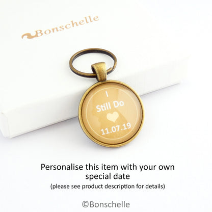 Round bronze toned keyring with the words I still Do, a small heart and a custom date