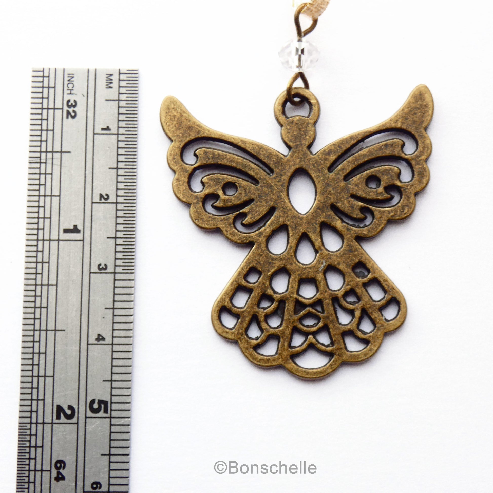 Antique bronze toned filigree style christmas angel ornament shown to scale.