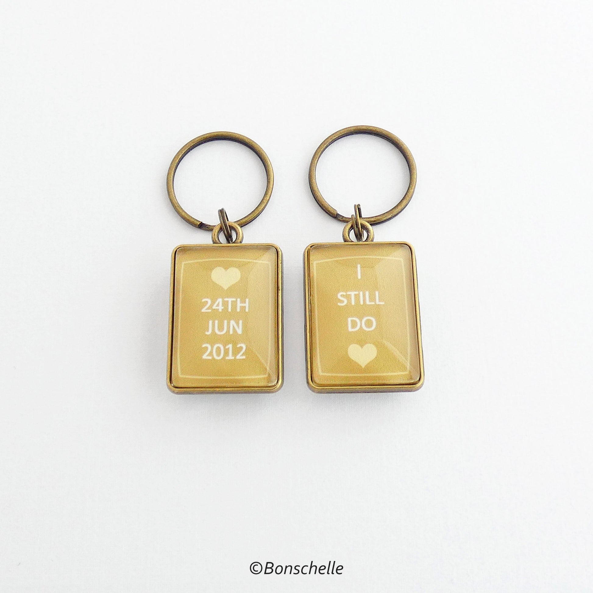 front and back view of the bronze toned metal and glass cabochon rectangle shape keyring for bronze anniversary with personalised date and the worlds I still do
