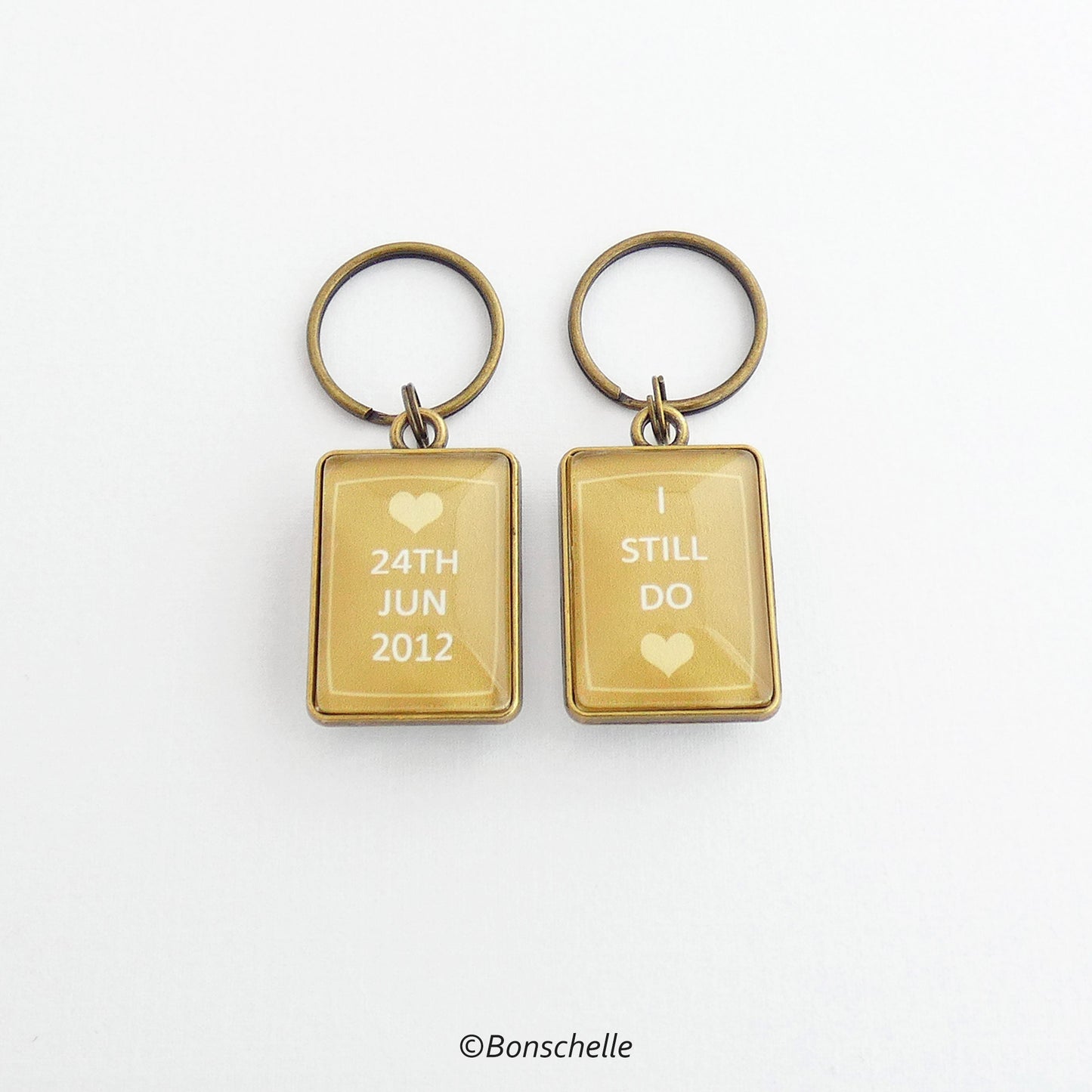 front and back view of the bronze toned metal and glass cabochon rectangle shape keyring for bronze anniversary with personalised date and the worlds I still do