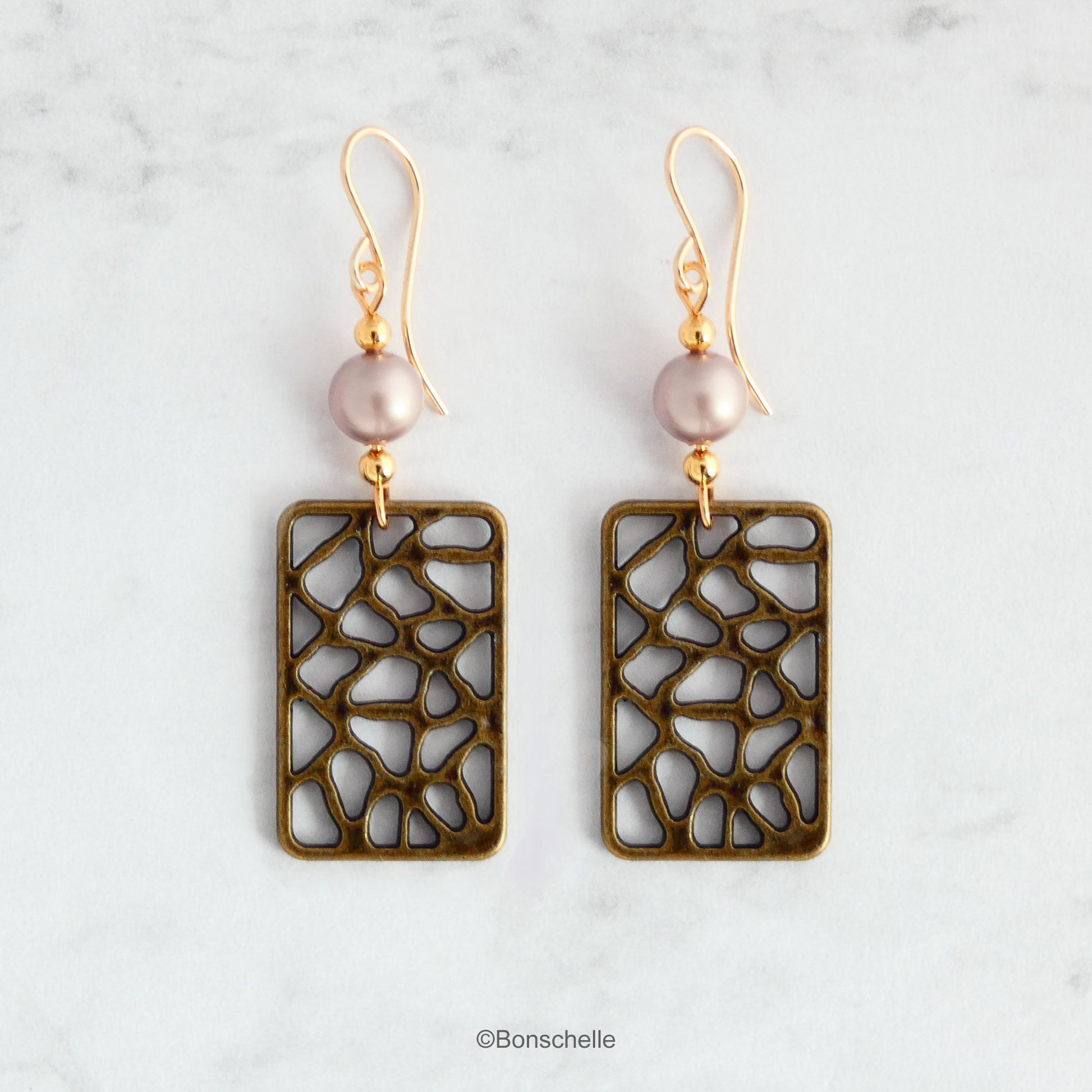 Handmade earrings made with rectangular shaped antique bronze filigree style charms, Swarovski simulated pearls in a light almond shade, gold toned beads and 14K gold filled earwires. 