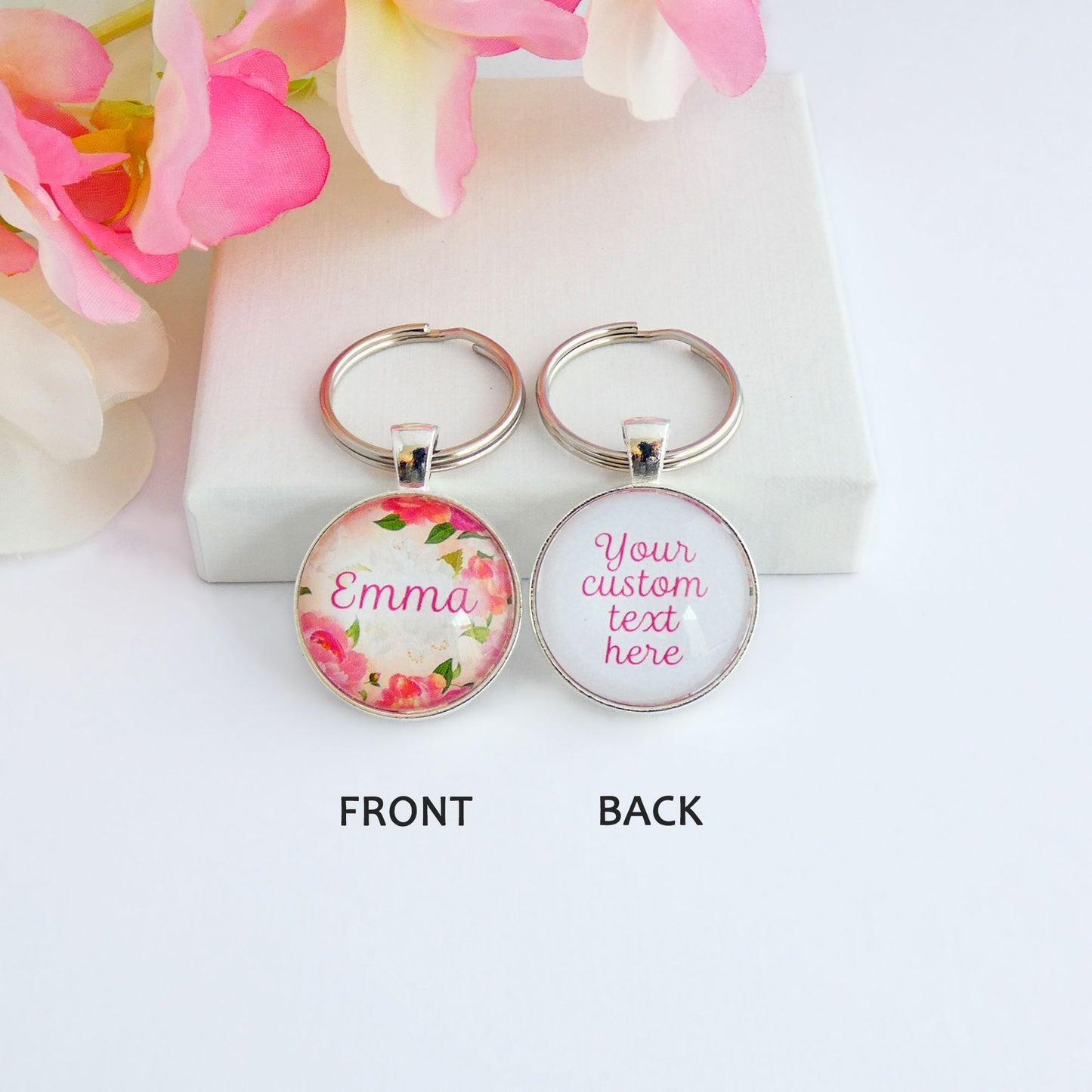 Another view of Double sided silver toned round keyring with a name and floral design on the front and your custom text on the back. 
