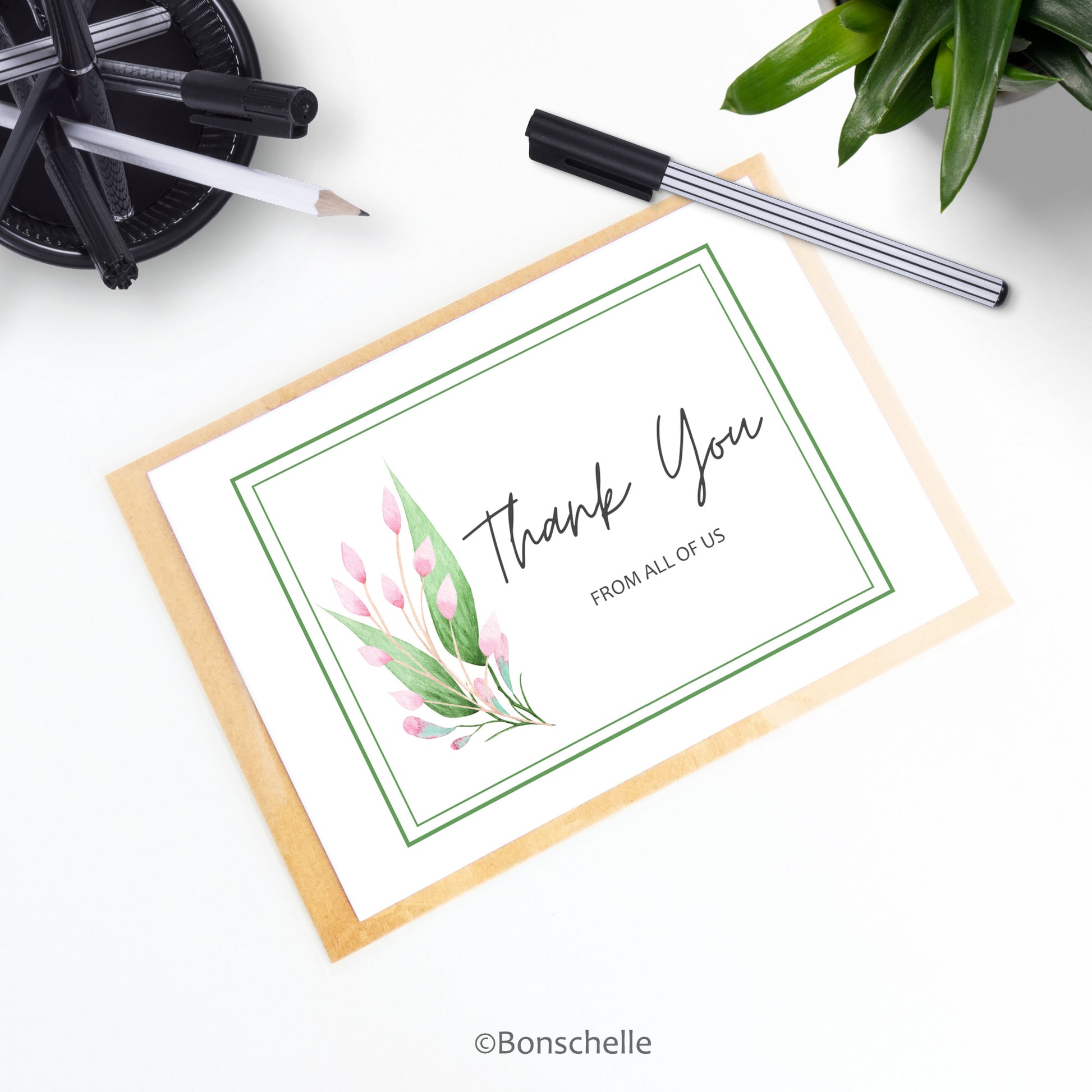 Handmade personalised Thank you card with pink buds and green leaves and custom text under the words 'Thank You. Floral blank inside thank you greeting card shown with a brown envelope on a desk