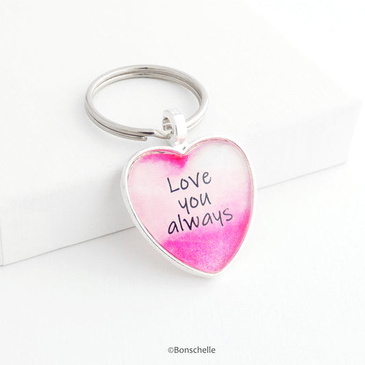 Silver toned heart shaped metal keyring with pink and white design and the worlds 'Love you Always' capped with a clear glass cabochon