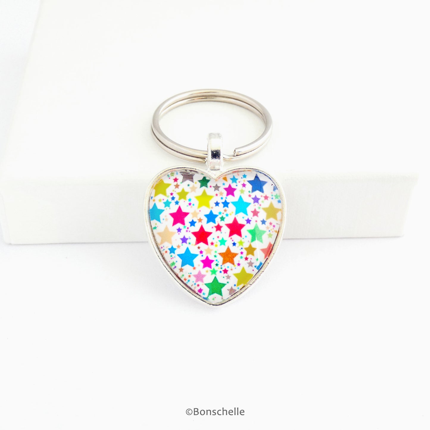 Heart shaped  silver toned keyring with a colourful star pattern