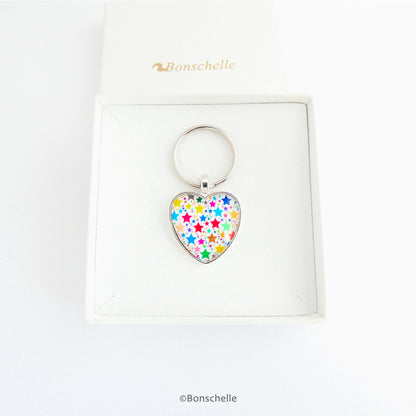 Heart shaped silver toned metal keyring with a colourful star pattern design capped wtih a clear glass cabochon. in a gfit box