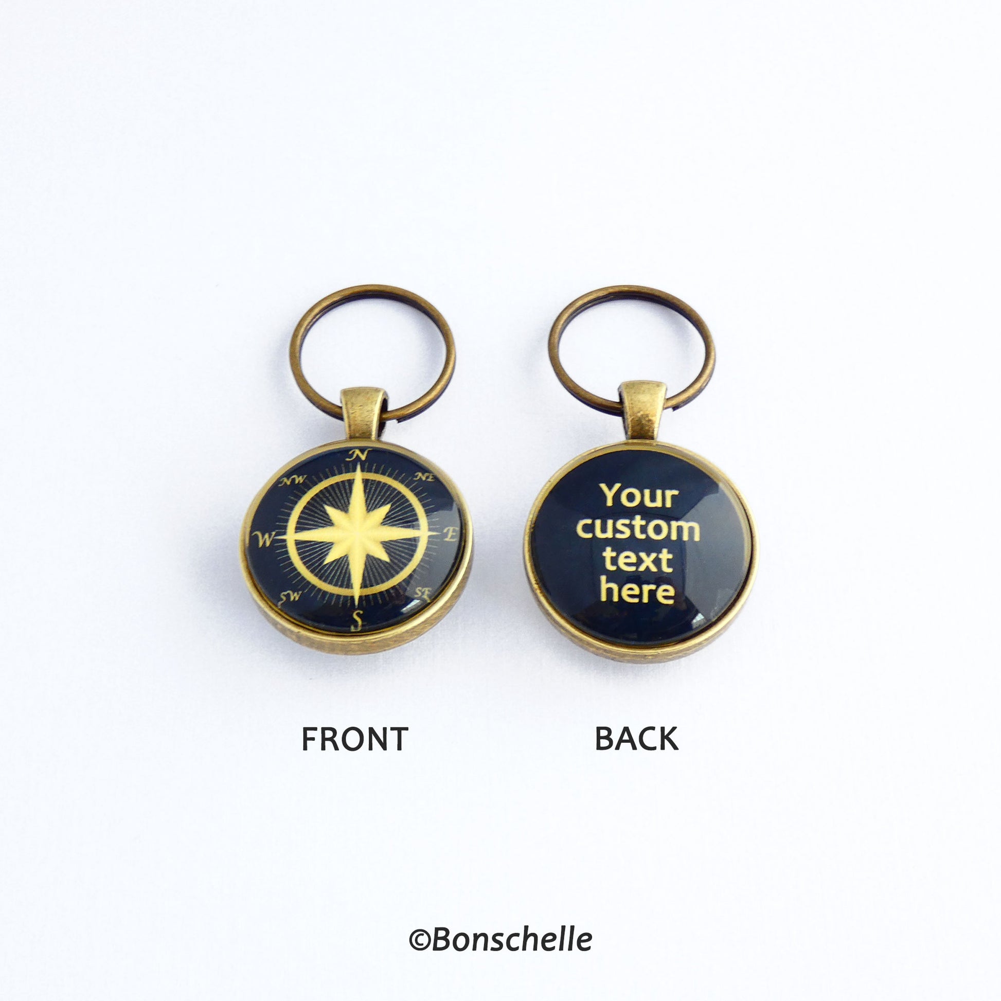 Front and back views of a personalised bronze metal round double sided keyring, with light bronze coloured compass rose on the front against a navy blue background, and the back wtih light bronze coloured text against a navy blue background.